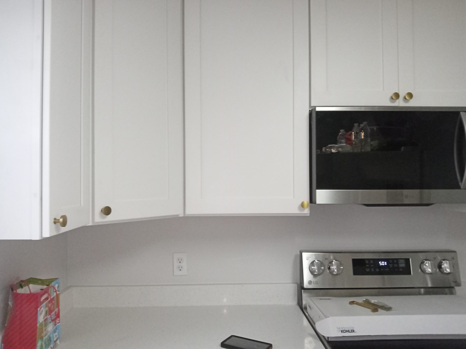 After: new white upper cabinets, quartz counters and stainless range