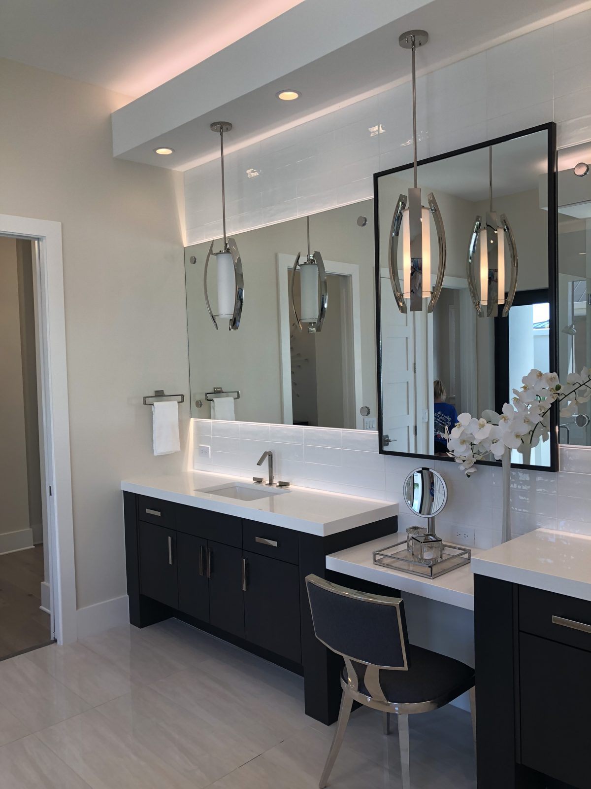 Primary bathroom with double vanity, makeup station and pendant lighting