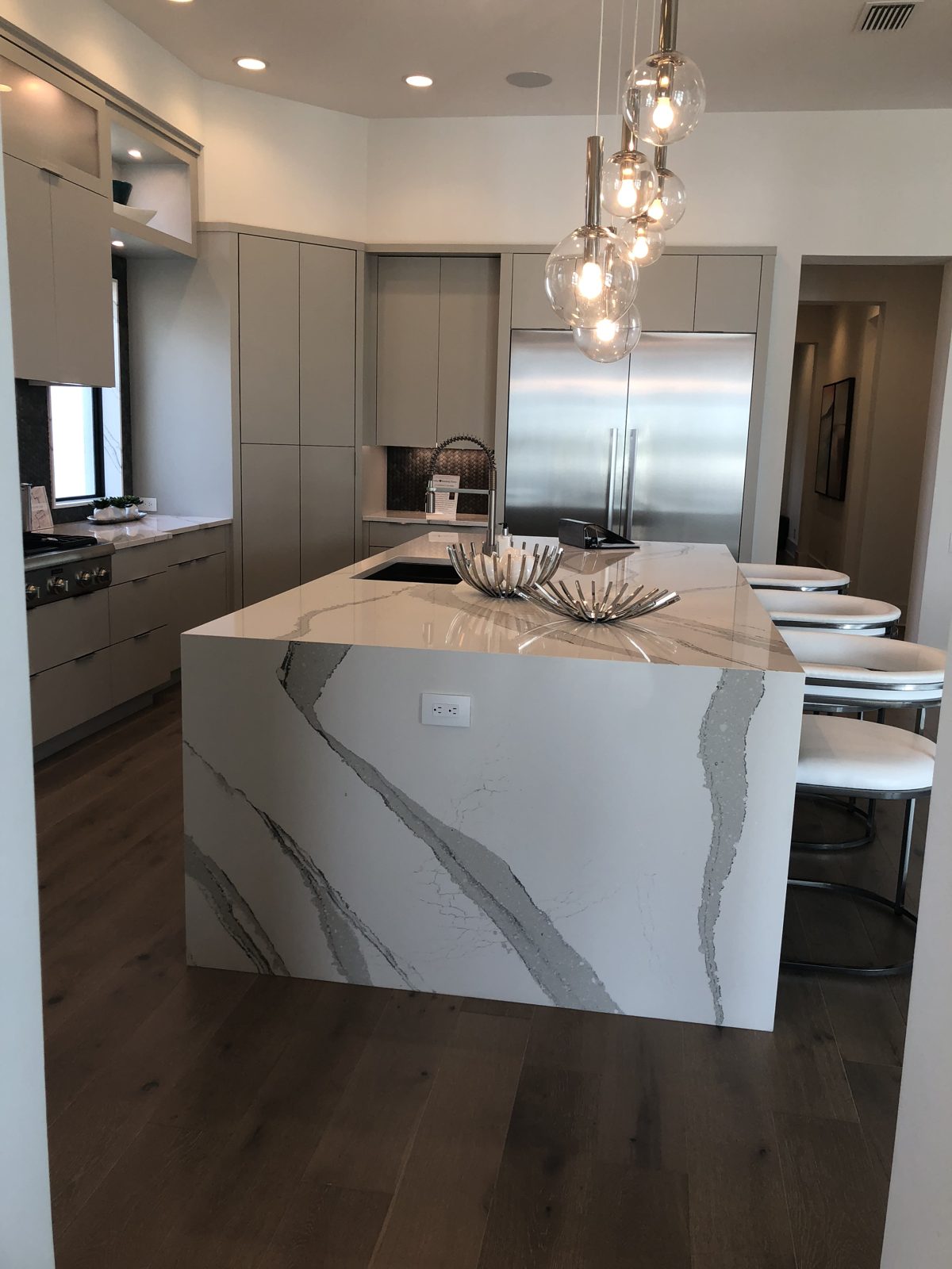 Kitchen with marble-look waterfall island and flat-panel cabinets